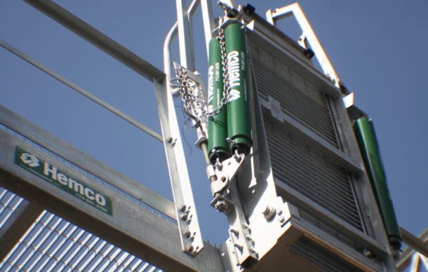 Hemco industrial fall protection self-closing safety gate on elevated platform stairway